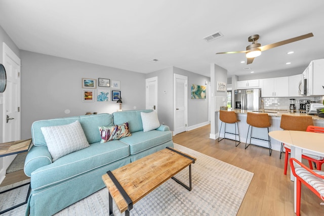 living room featuring ceiling fan and light wood-type flooring