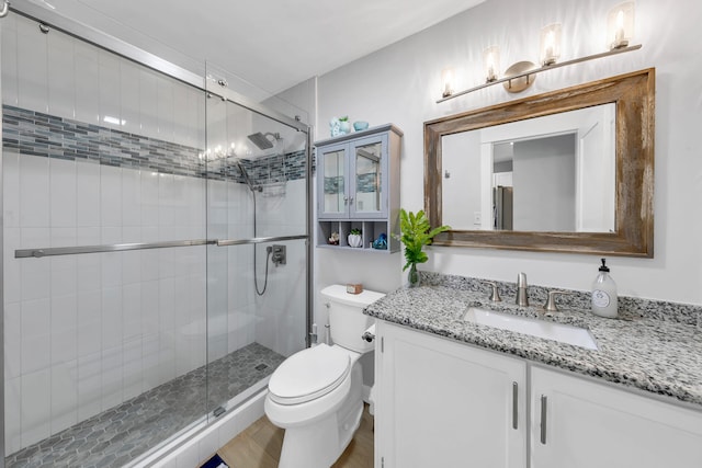 bathroom with vanity, toilet, and a shower with shower door