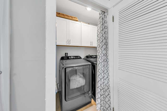 laundry room with cabinets and washer and clothes dryer