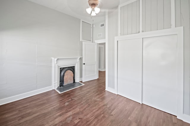 unfurnished living room featuring dark wood-type flooring and ceiling fan