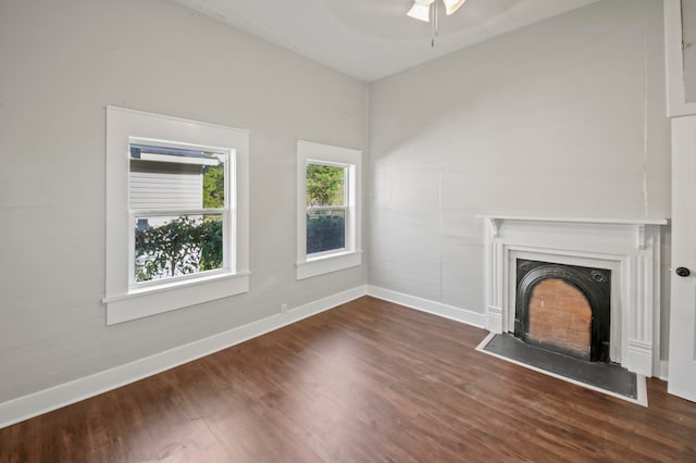 unfurnished living room with dark hardwood / wood-style floors and ceiling fan