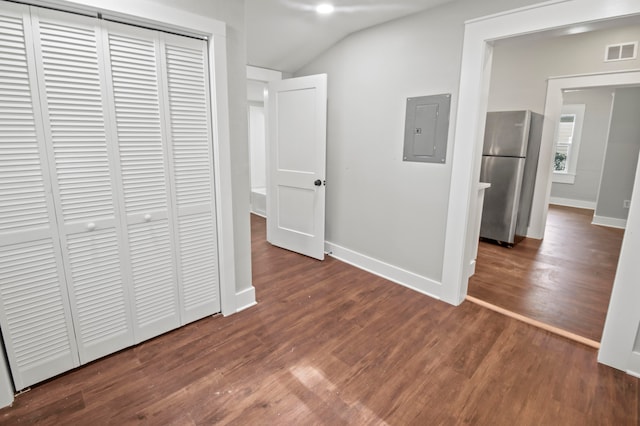 corridor featuring dark wood-type flooring, lofted ceiling, and electric panel