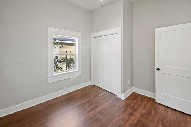 unfurnished bedroom featuring dark wood-type flooring and a closet