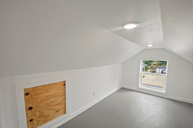 bonus room with hardwood / wood-style flooring, a textured ceiling, and lofted ceiling