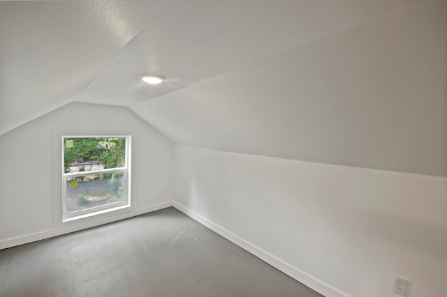 additional living space featuring lofted ceiling and a textured ceiling