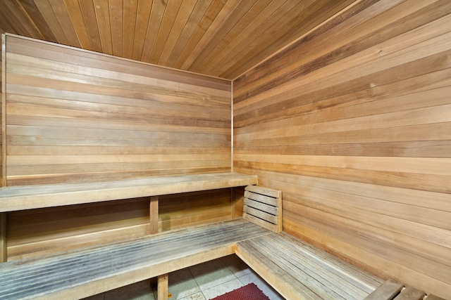 view of sauna with tile patterned floors and wooden ceiling