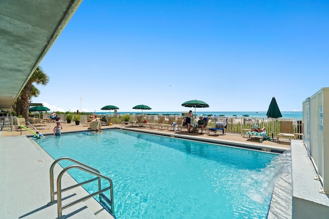 view of pool featuring a patio area and a water view