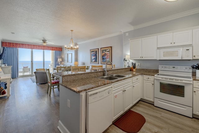 kitchen featuring kitchen peninsula, white cabinets, a water view, and white appliances