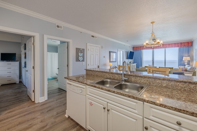 kitchen featuring a textured ceiling, sink, white dishwasher, and wood-type flooring