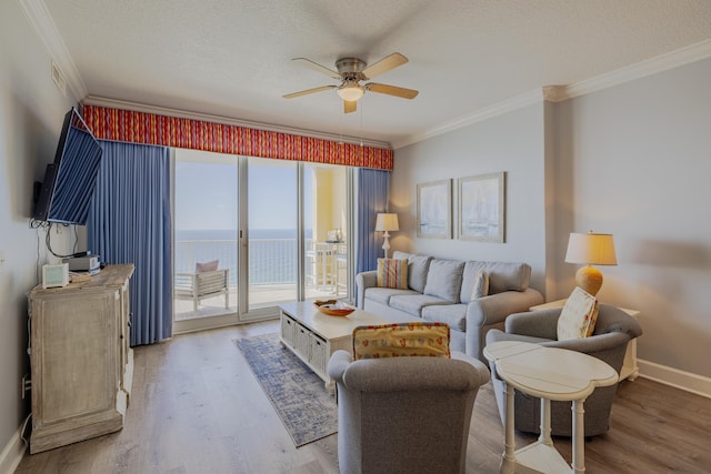 living room with ornamental molding, hardwood / wood-style flooring, and ceiling fan