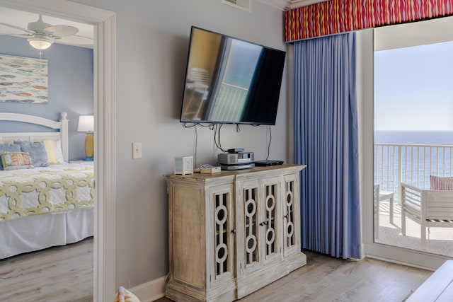 bedroom with access to outside, hardwood / wood-style flooring, and ceiling fan