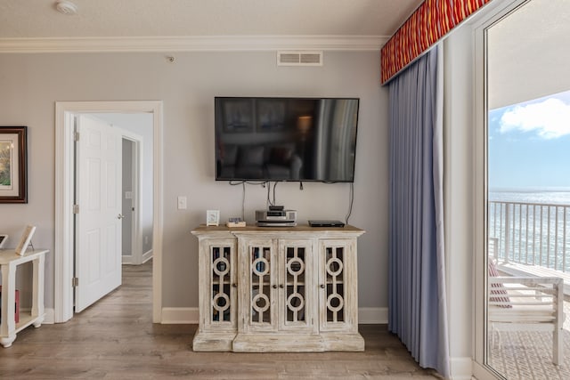 living room with hardwood / wood-style flooring, ornamental molding, and a textured ceiling