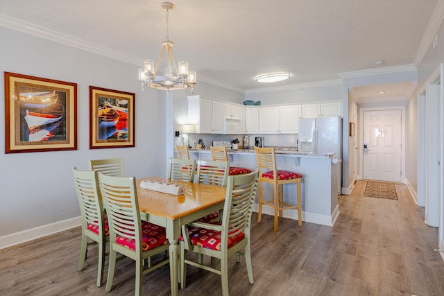 dining area with light hardwood / wood-style floors, crown molding, and an inviting chandelier