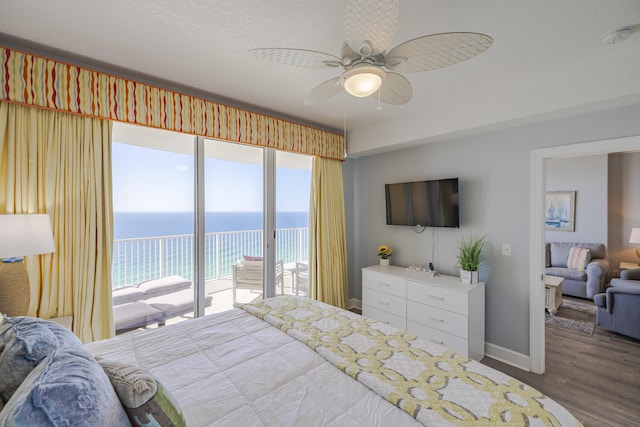 bedroom featuring ceiling fan, access to outside, multiple windows, and hardwood / wood-style floors