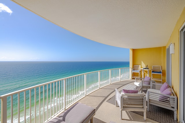 balcony with a water view and a view of the beach