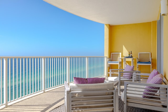 balcony with a water view and an outdoor living space