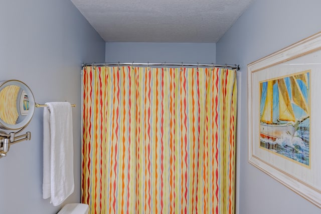 bathroom with toilet and a textured ceiling