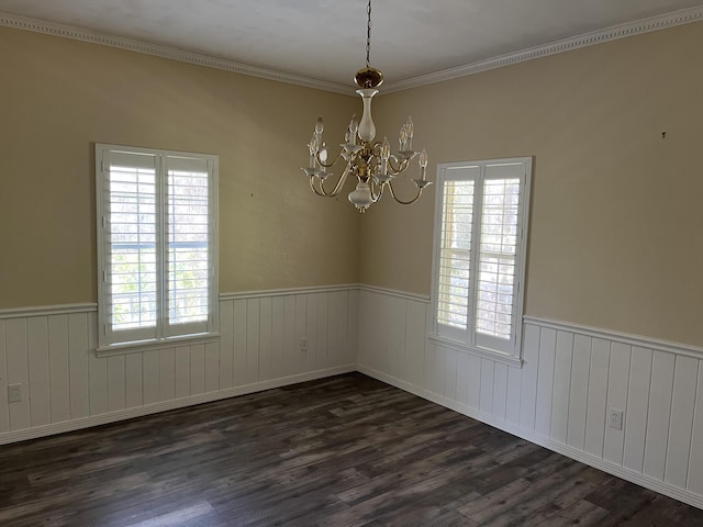 unfurnished room with a wainscoted wall, dark wood finished floors, and an inviting chandelier