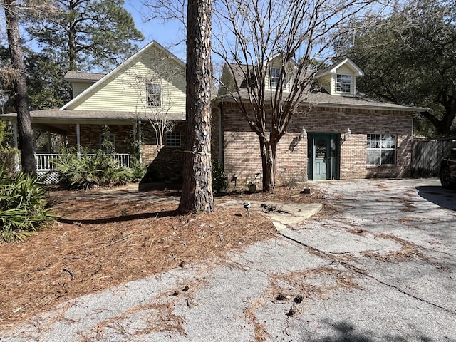 view of front of property featuring covered porch and brick siding