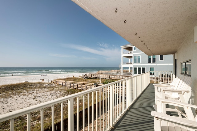 balcony featuring a water view and a beach view