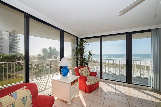 sunroom / solarium with a water view, a view of the beach, and plenty of natural light