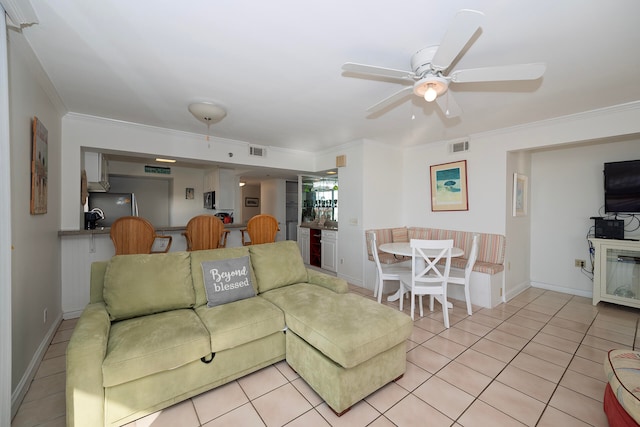 living room featuring ornamental molding, light tile patterned floors, and ceiling fan