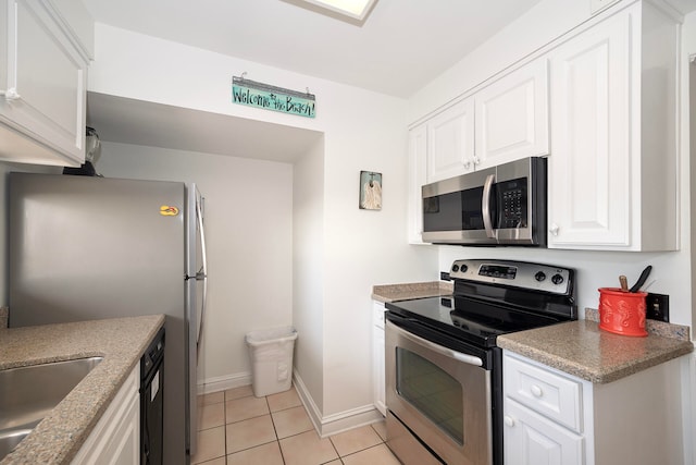 kitchen with light tile patterned flooring, white cabinets, stainless steel appliances, and sink