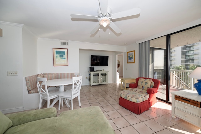 living room featuring crown molding, light tile patterned floors, a wall of windows, and ceiling fan