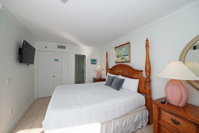 bedroom featuring a closet, ornamental molding, and light tile patterned floors