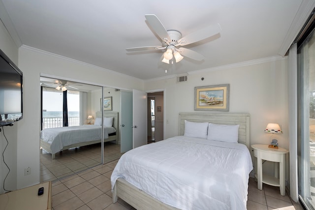 tiled bedroom with a closet, ceiling fan, and crown molding