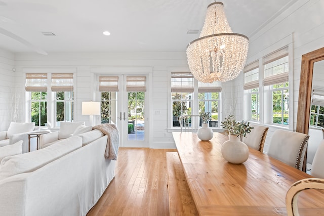 sunroom with a chandelier and french doors