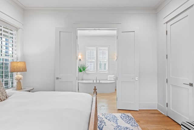 bedroom with light wood-type flooring and crown molding