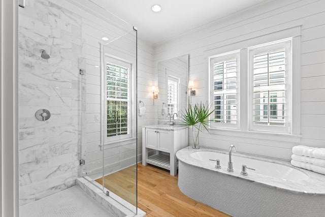 bathroom featuring hardwood / wood-style flooring, vanity, a healthy amount of sunlight, and plus walk in shower