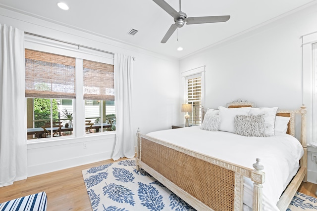 bedroom with ornamental molding, hardwood / wood-style floors, and ceiling fan