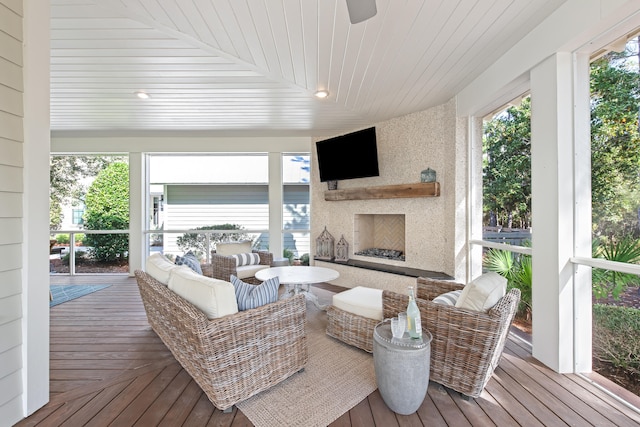 sunroom featuring wood ceiling, vaulted ceiling, and an outdoor fireplace