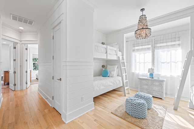 bedroom featuring multiple windows, hardwood / wood-style floors, and ornamental molding