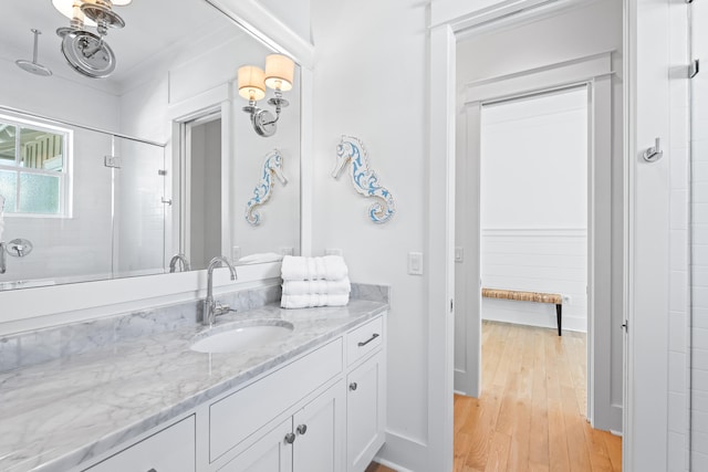 bathroom featuring walk in shower, hardwood / wood-style flooring, vanity, and crown molding