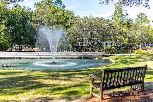 view of home's community with a lawn and a water view