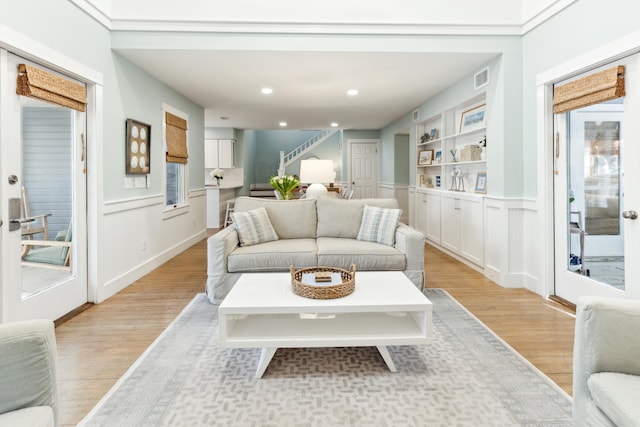 living room with light hardwood / wood-style flooring and built in shelves