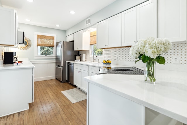 kitchen featuring appliances with stainless steel finishes, white cabinetry, and a healthy amount of sunlight