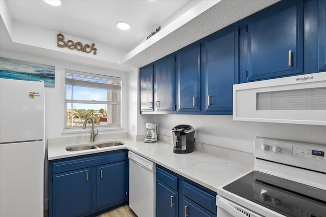 kitchen with blue cabinetry, sink, and white appliances