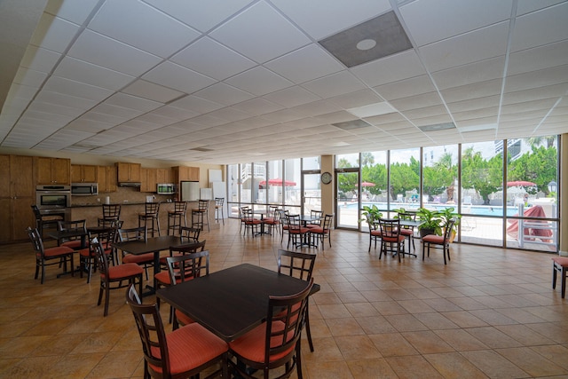 dining area featuring a wall of windows and light tile patterned floors