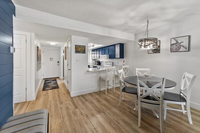 dining area featuring hardwood / wood-style floors, a notable chandelier, and a textured ceiling