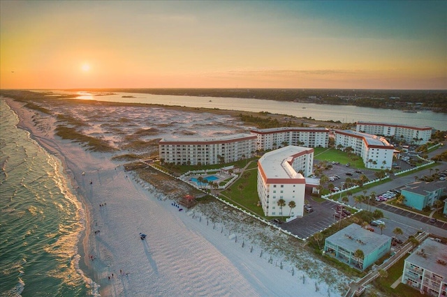 aerial view at dusk with a view of the beach and a water view