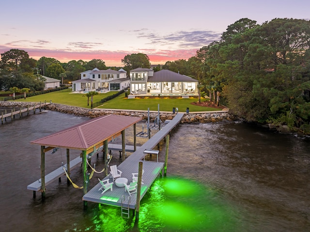 view of dock with a water view and a yard