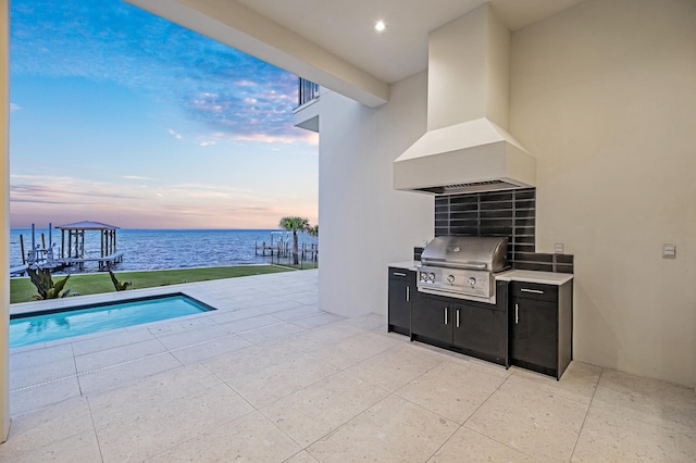 patio terrace at dusk featuring a water view and grilling area