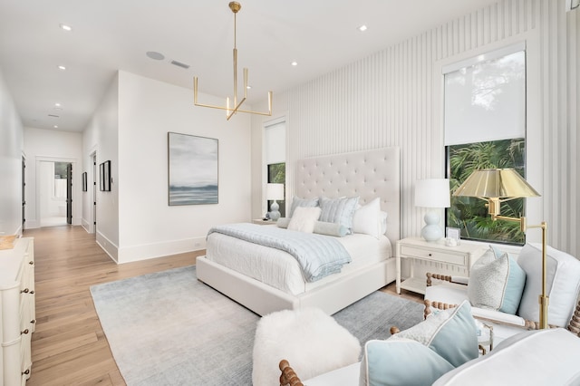 bedroom with an inviting chandelier, light hardwood / wood-style floors, and multiple windows