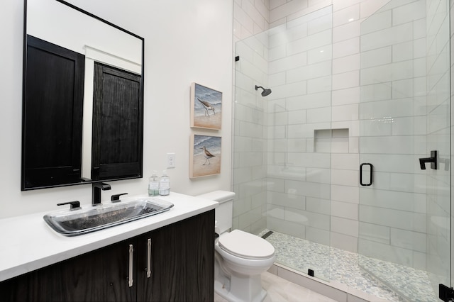 bathroom featuring an enclosed shower, vanity, and toilet