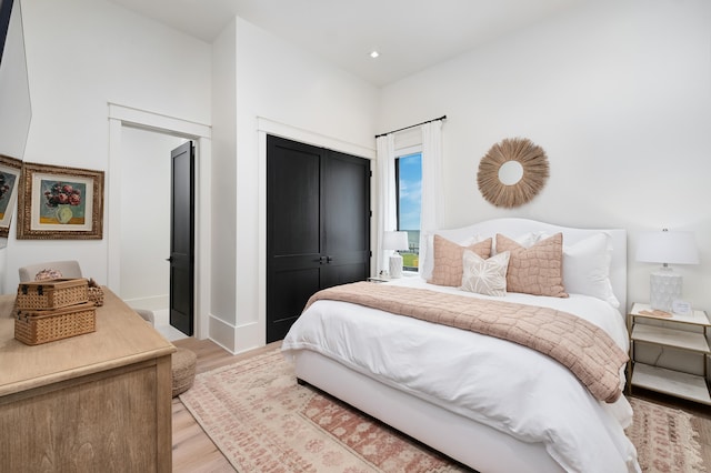 bedroom with light wood-type flooring and a closet