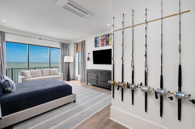 bedroom featuring a water view and light wood-type flooring